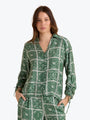 Woman wearing a green patterned shirt on a white background