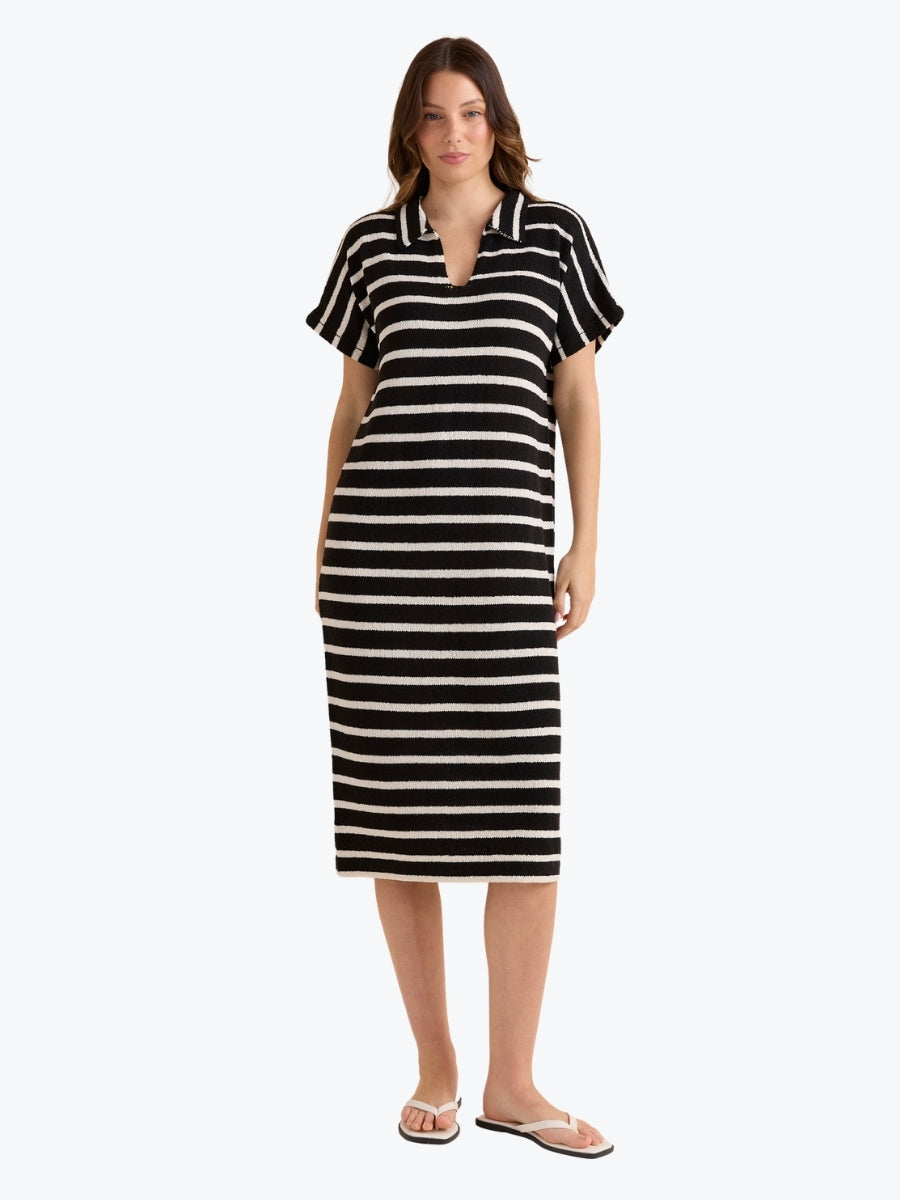 Woman wearing a black and white striped dress on a white background