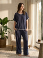 Woman wearing a grey jersey set  in a cozy living room.