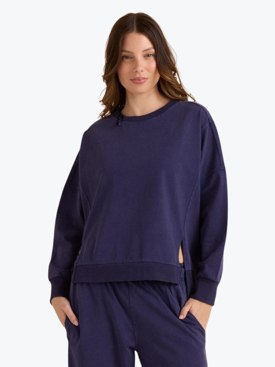 Woman wearing a navy blue sweatshirt and pants on a white background