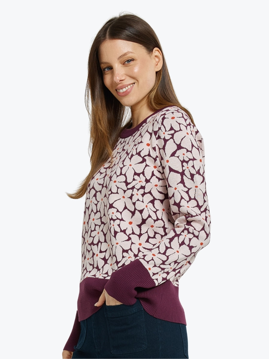 Woman wearing a floral patterned sweater on a white background