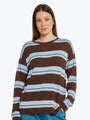 Woman wearing a brown and blue striped sweater on a white background