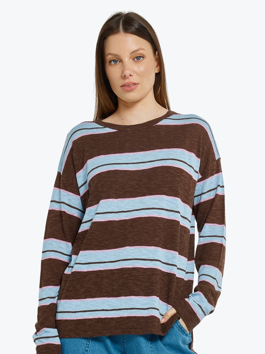 Woman wearing a brown and blue striped sweater on a white background