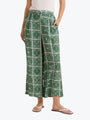 Green patterned pants worn by a person on a white background
