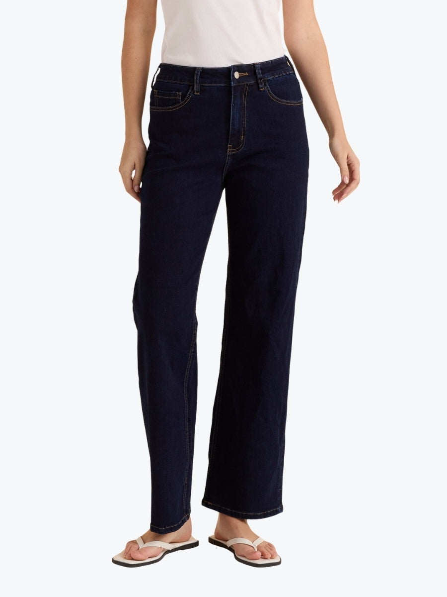 Person wearing dark blue jeans on a white background