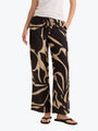 Person wearing black and beige patterned pants on a white background