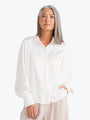Woman wearing a white blouse against a white background