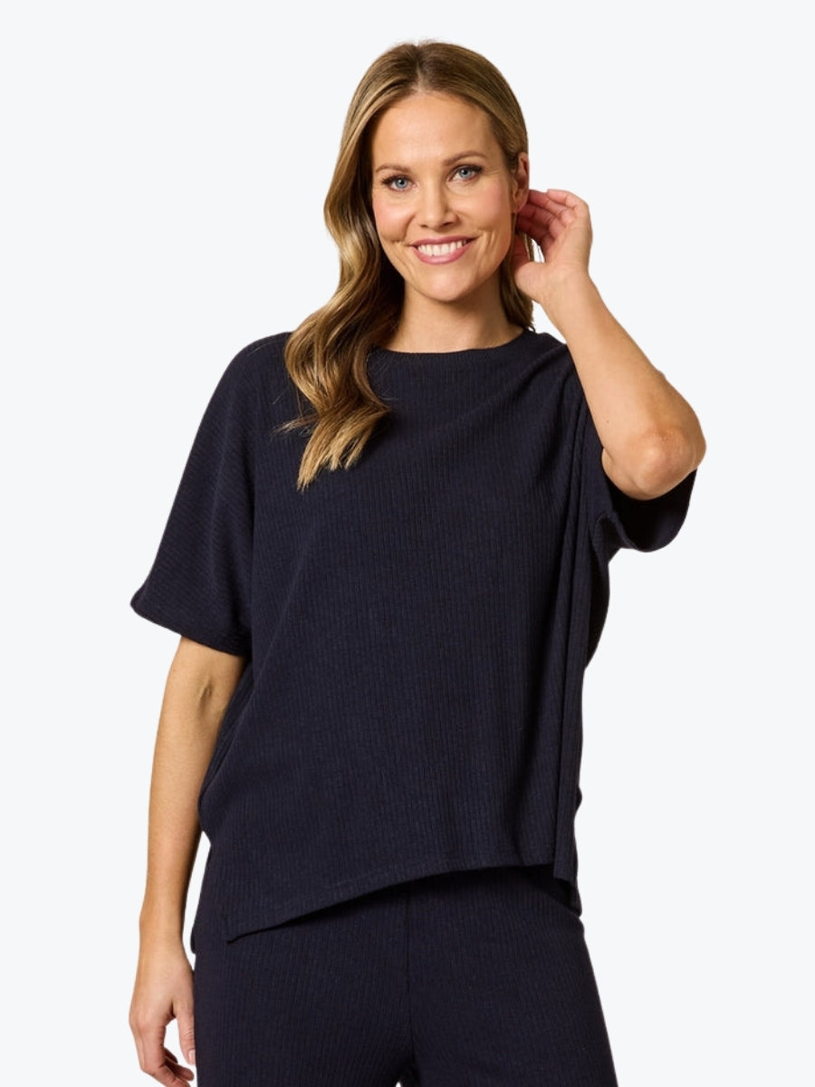 Woman wearing a navy blue top and pants on a white background