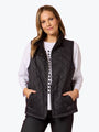 Woman wearing a black quilted vest on a white background