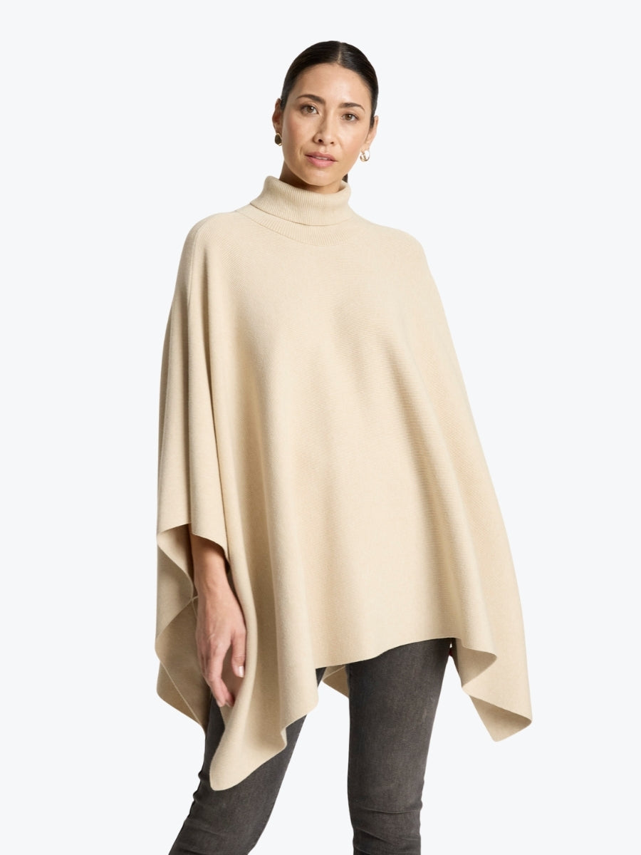 Woman wearing a beige poncho on a white background