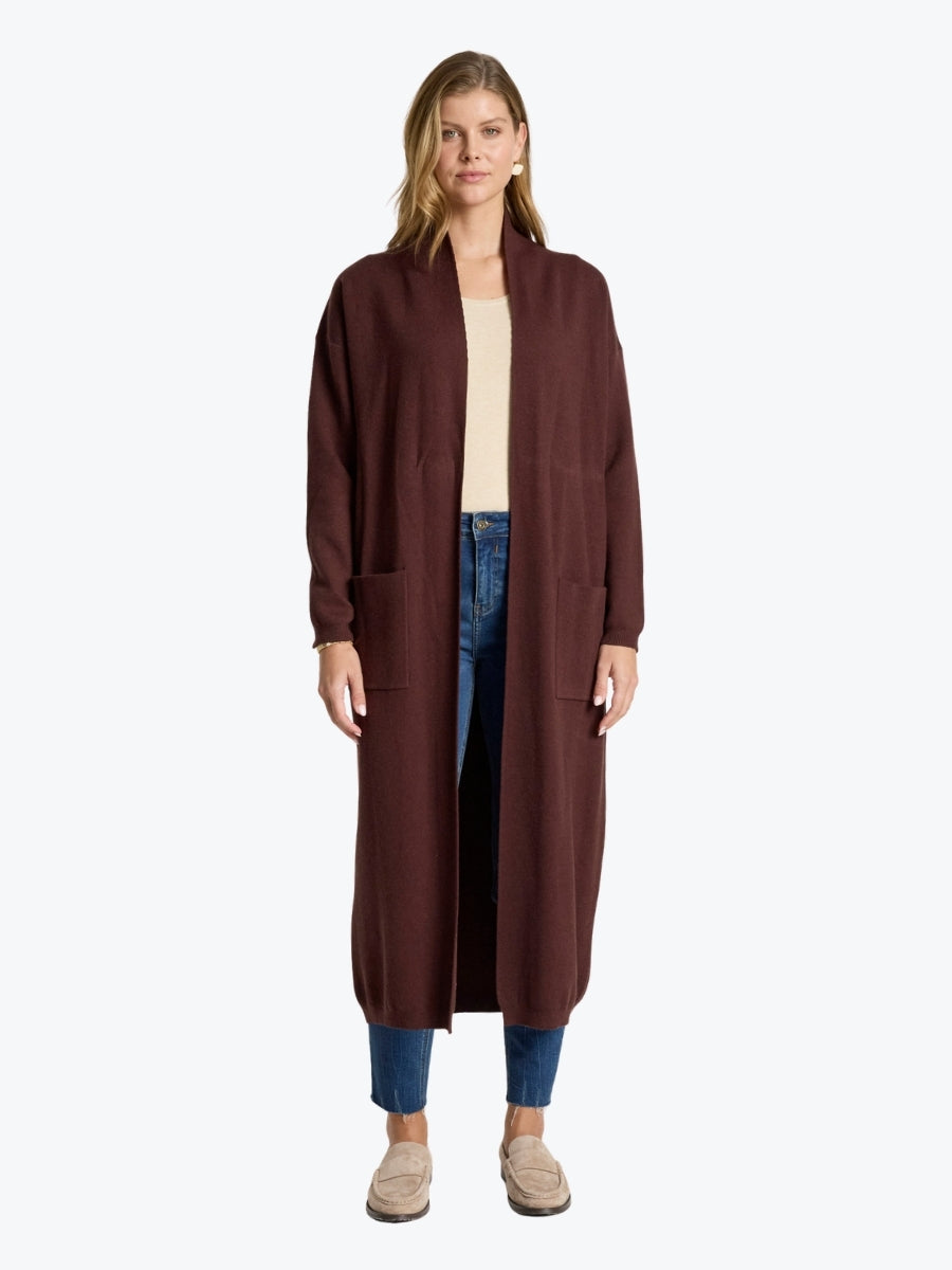 Woman wearing a long brown cardigan on a white background
