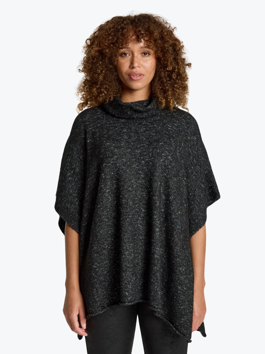Woman wearing a dark gray poncho against a white background