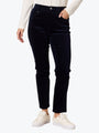 Person wearing black jeans and white sneakers on a white background