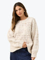 Woman wearing a cream knitted sweater on a white background