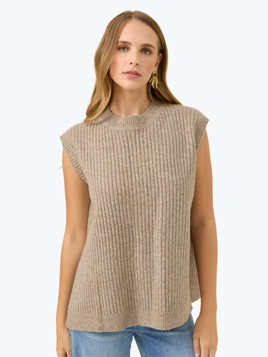 Woman wearing a beige sleeveless knitted top on a white background