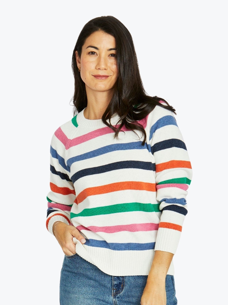 Woman wearing a colorful striped sweater on a white background