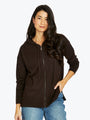 Woman wearing a brown zip-up hoodie and blue jeans on a white background