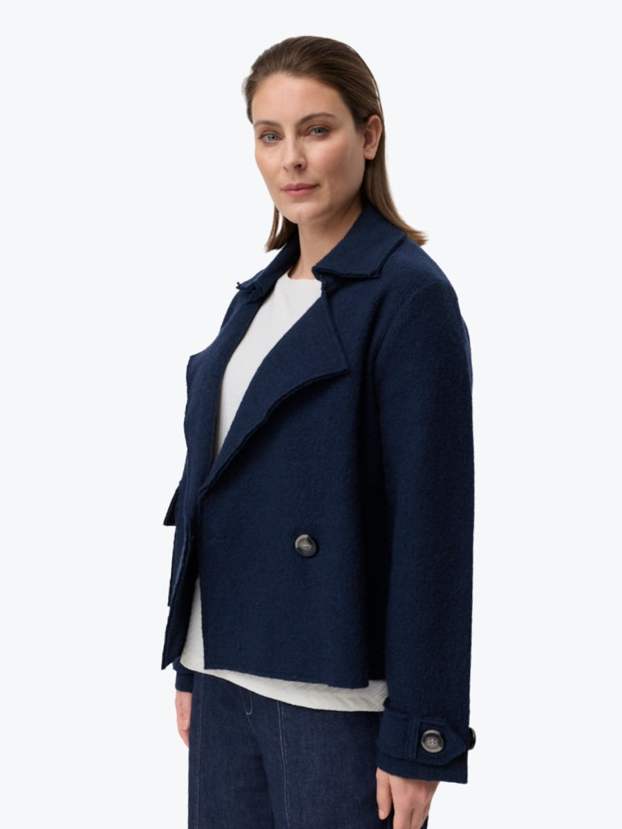 Woman wearing a navy blue coat on a white background