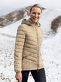 Woman wearing a beige puffer jacket in a snowy landscape