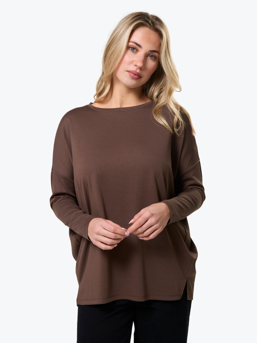 Woman wearing a brown long-sleeve top on a white background