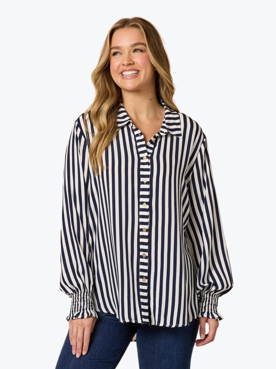 Woman wearing a navy and white striped shirt on a white background