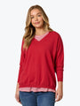 Woman wearing a red sweater with a striped pattern on a white background
