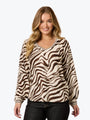 Woman wearing a zebra print sweater on a plain background