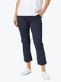 Person wearing navy pants and white sneakers on a white background