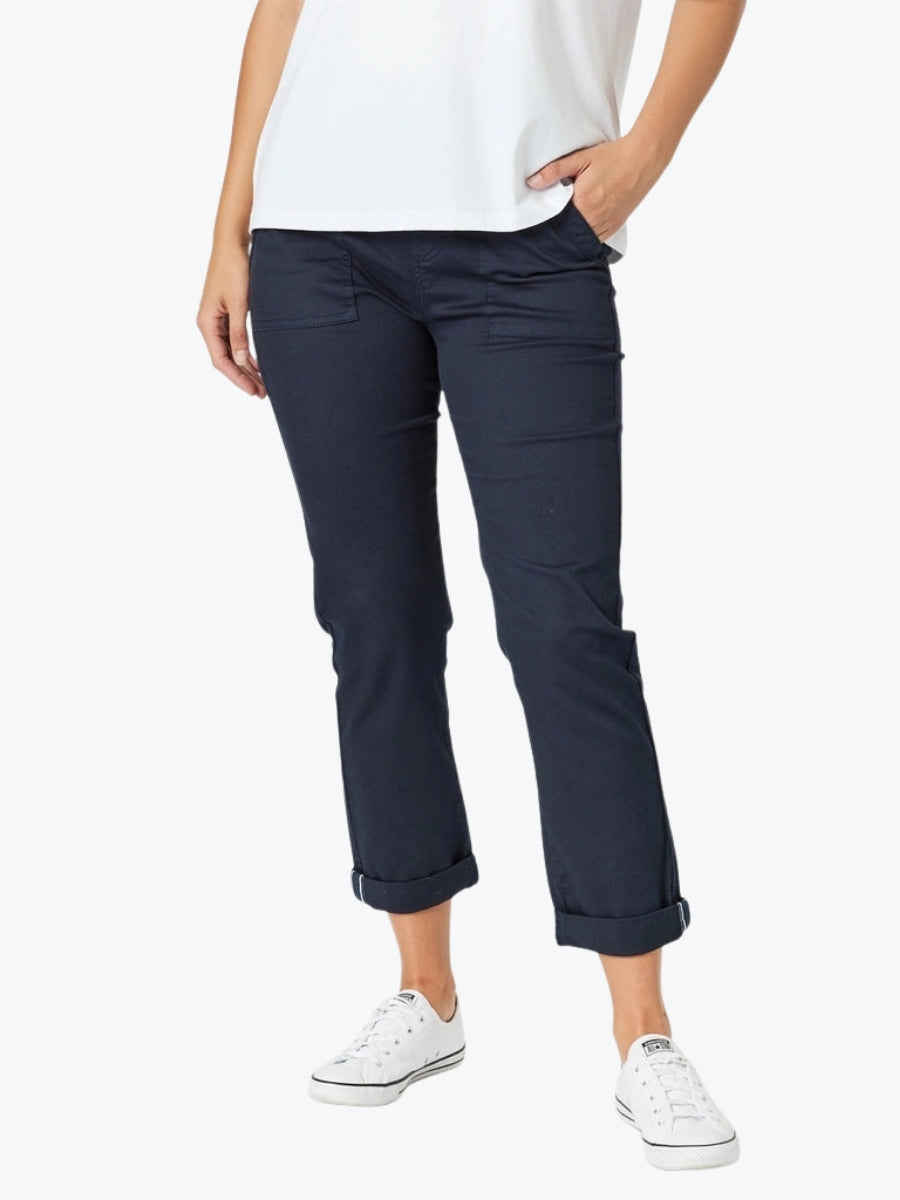 Person wearing navy pants and white sneakers on a white background