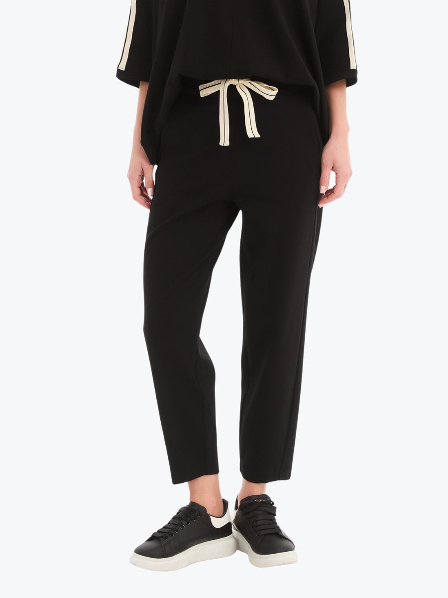 Person wearing a black outfit with a drawstring waistband on a white background