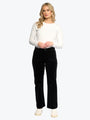 Woman wearing a white long-sleeve top and black pants on a white background