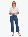 Woman wearing a white blouse and blue jeans on a white background