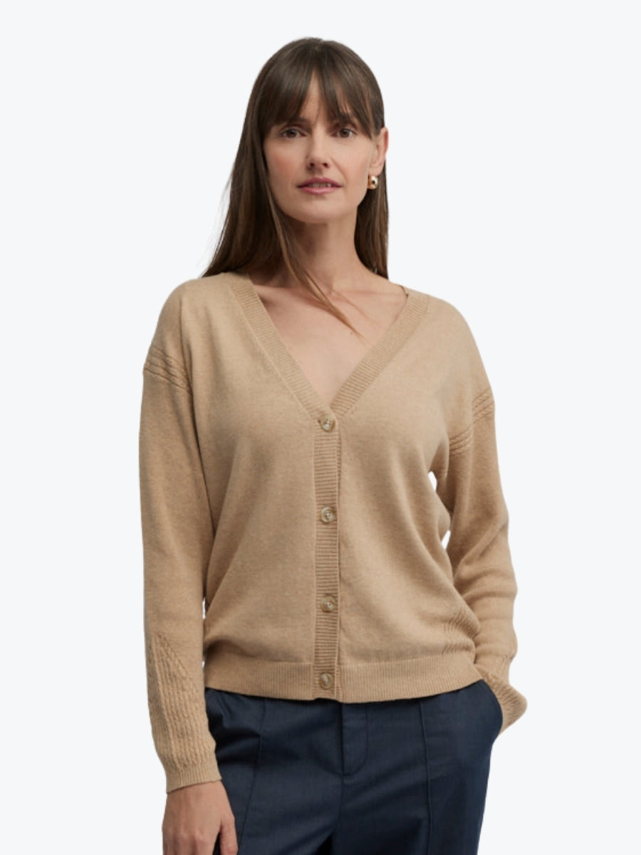 Woman wearing a beige cardigan on a white background