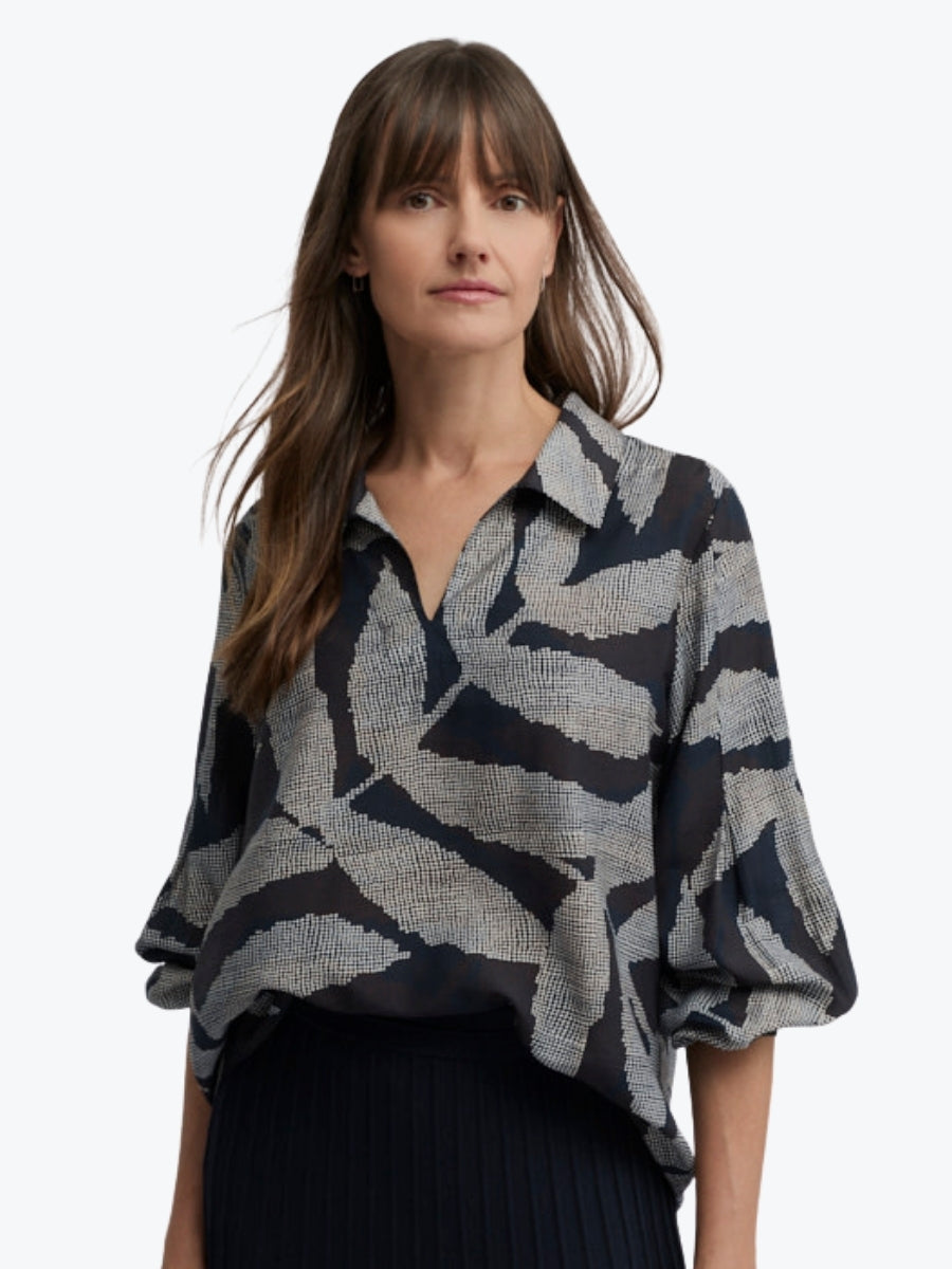 Woman wearing a patterned shirt on a white background