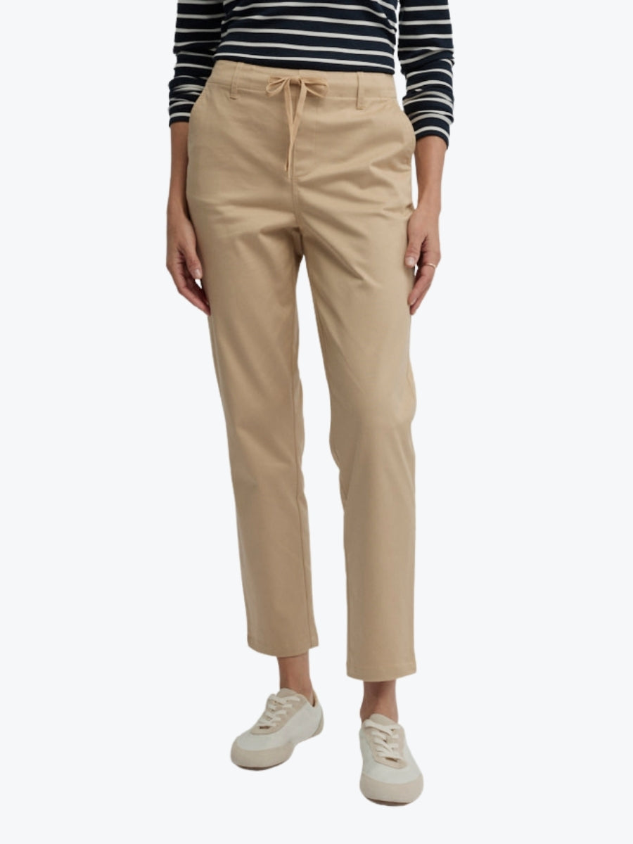 Person wearing beige pants and a striped shirt on a white background