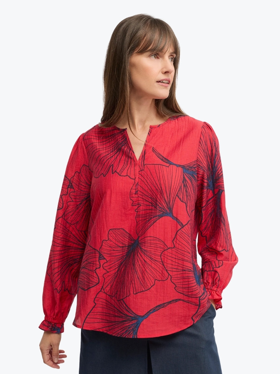 Woman wearing a red floral blouse on a white background